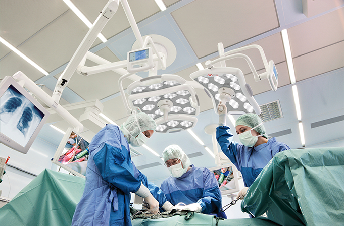 Kolme kirurgian työskentelee leikkauksessa